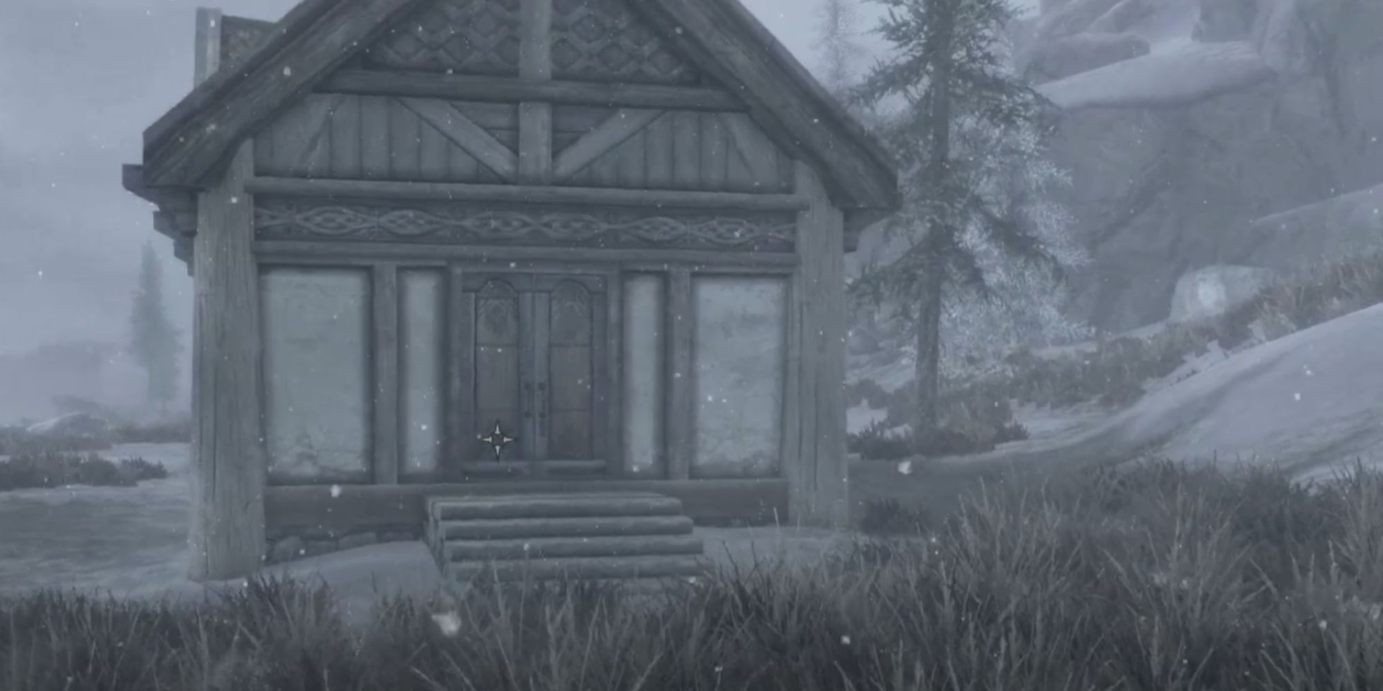 the front of windstad manor in the snow, a snowy hill behind it