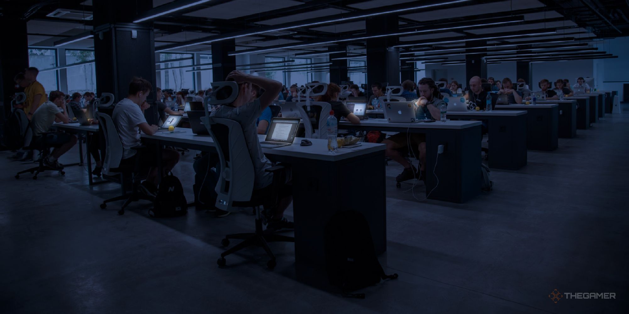 An Office at night with lots of tired looking workers