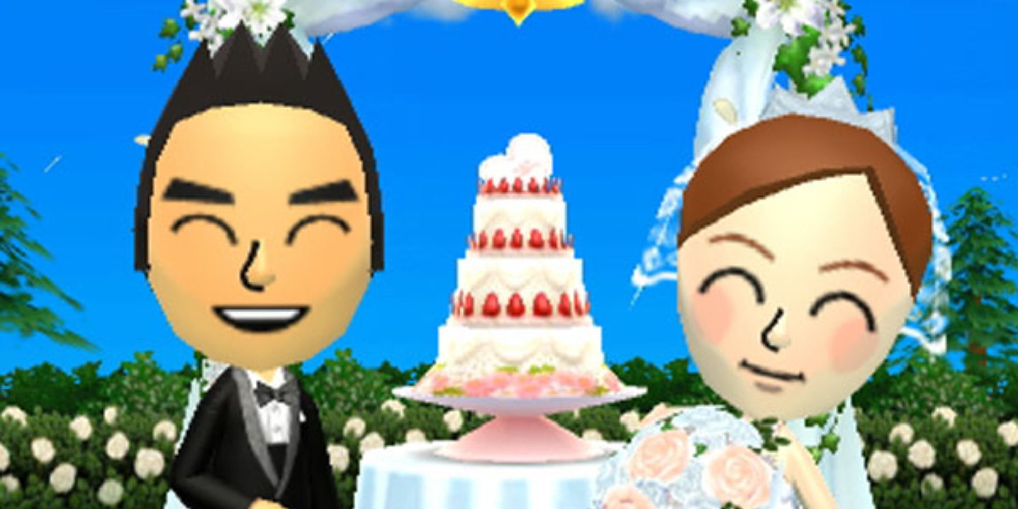 A bride and groom smiling at the camera in front of their wedding cake