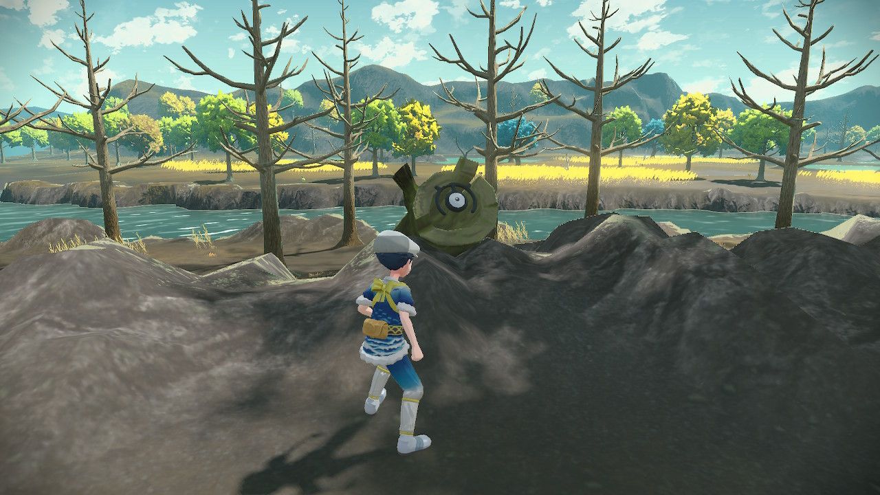 Pokemon Trainer standing beside Unown M sitting on a stump, in Pokemon Legends Arceus.