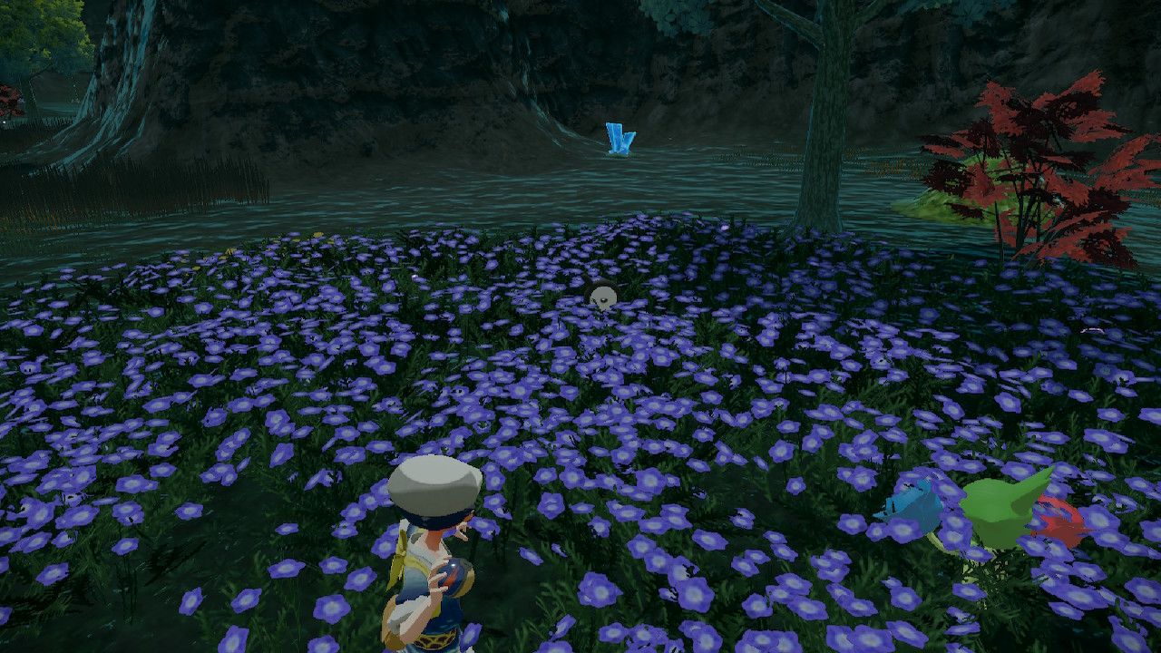 Pokemon Trainer aiming his pokeball at Unown P siting across a flower field, in Pokemon Legends Arceus.