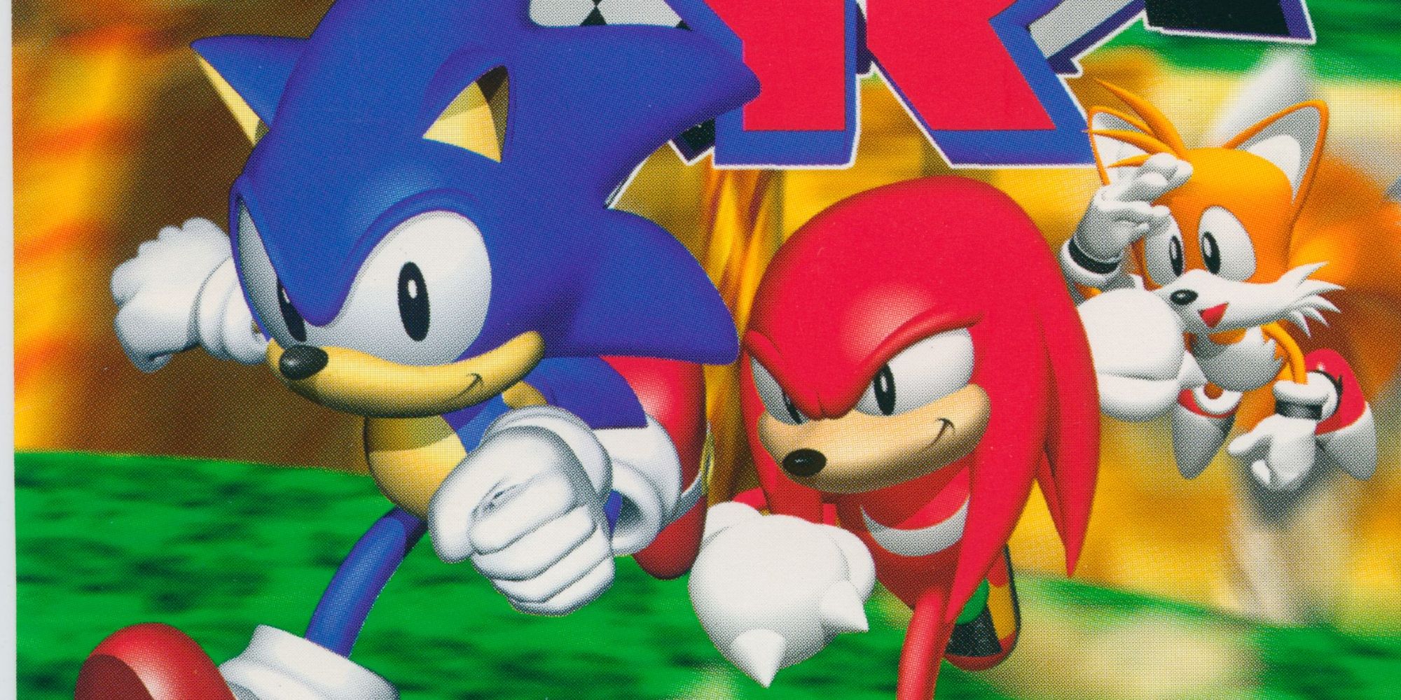 A section of the cover art from Sonic R, showing Sonic, Knucles, and Tails running toward the camera smirking
