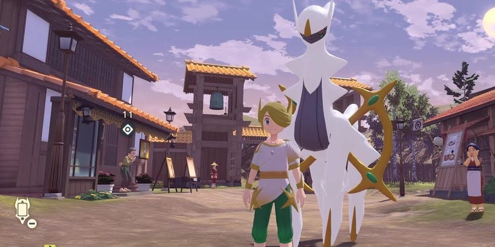 The Pokemon Legends Arceus trainer wearing the Sinnoh outfit, standing next to Arceus in Jubilife Village.