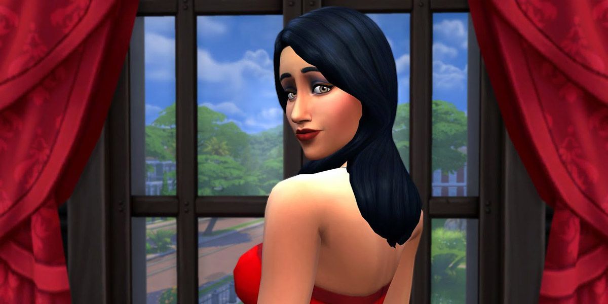 Bella Goth strikes a look-over-the-shoulder pose in front of a grand window with oppulent curtains.
