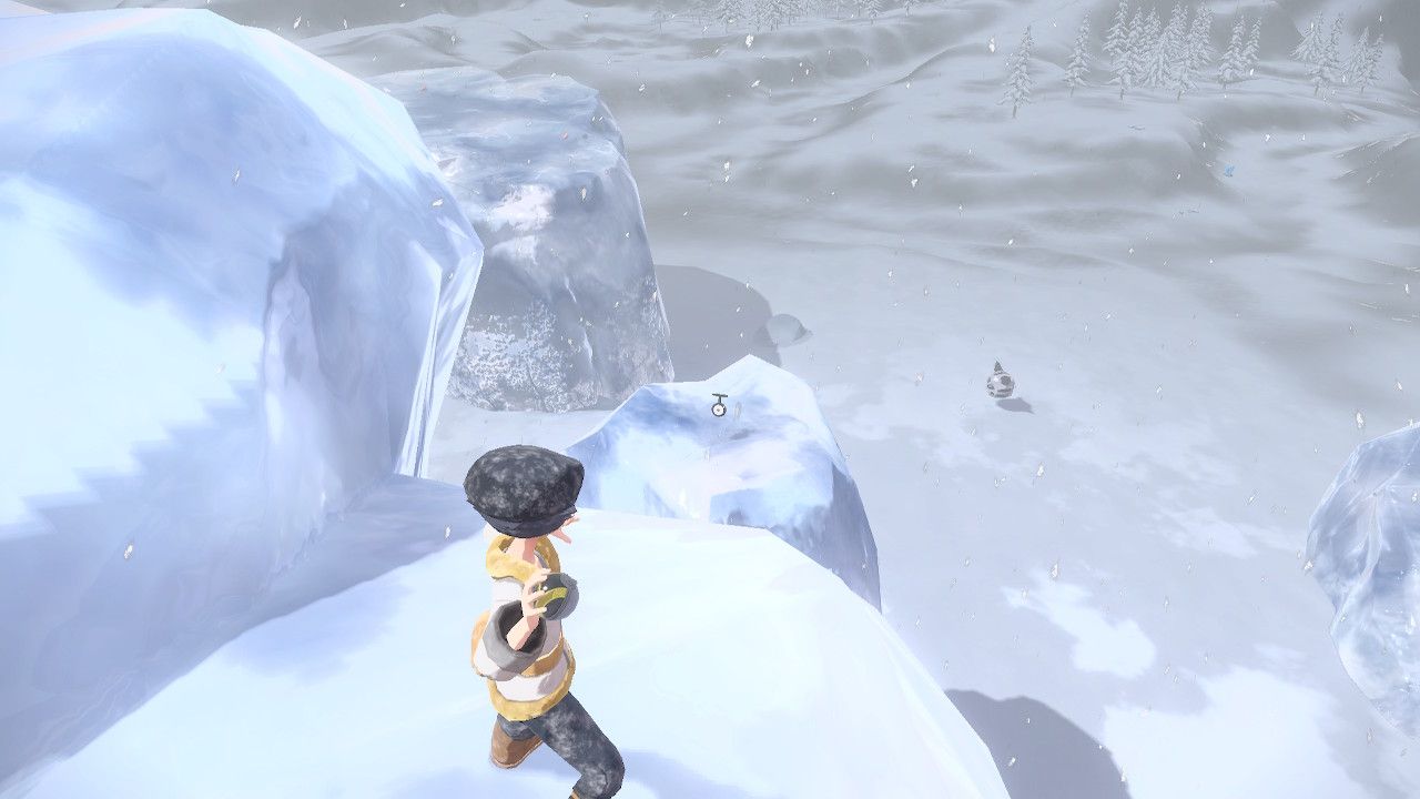 Pokemon Trainer aiming his pokeball at Unown T, who sits on top of an icy mountain in Pokemon Legends Arceus.