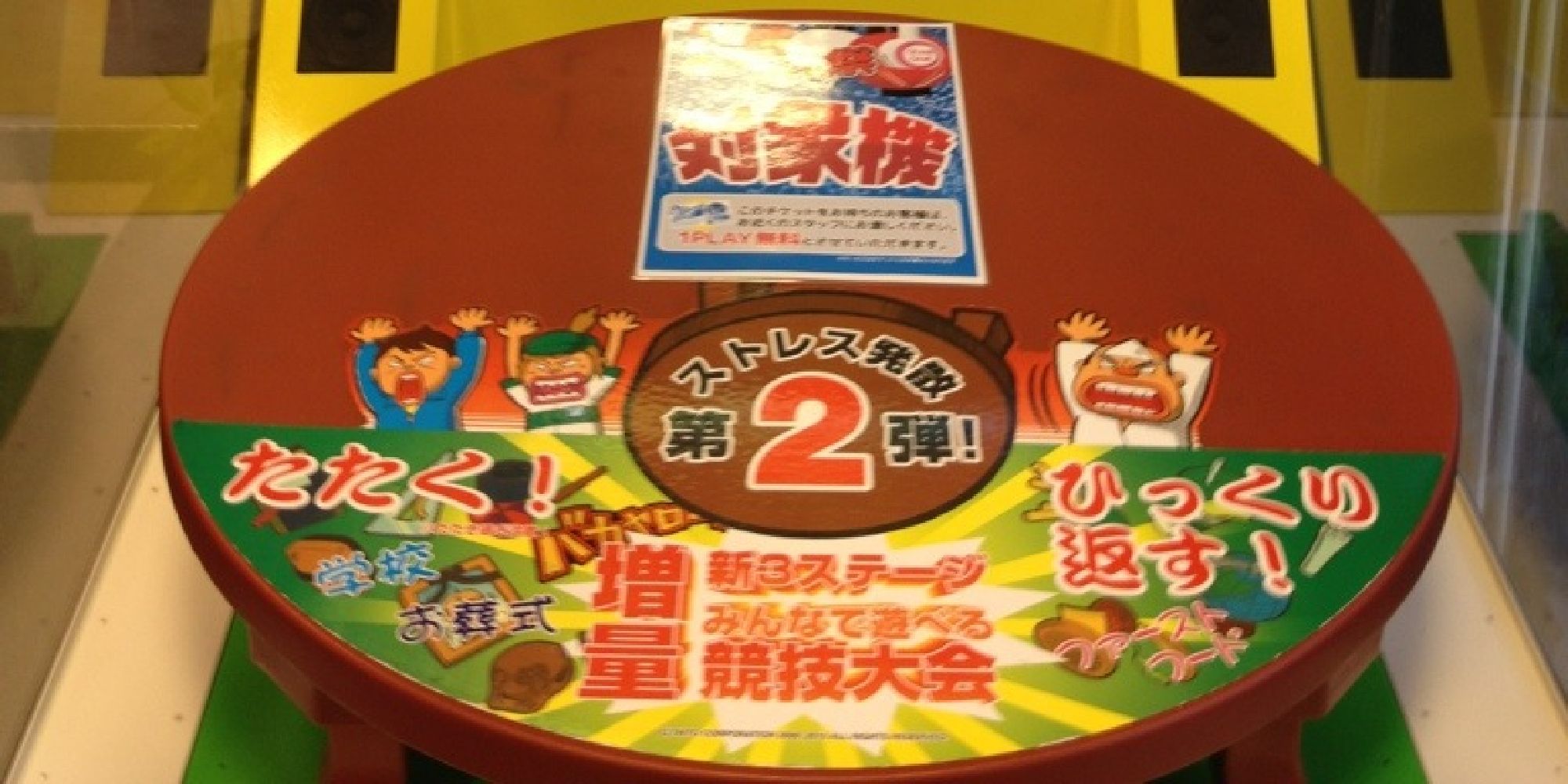 A photo of the Cho Chabudai Gaeshi 2 arcade machine, showing its unique table controller with angry chibi people on it
