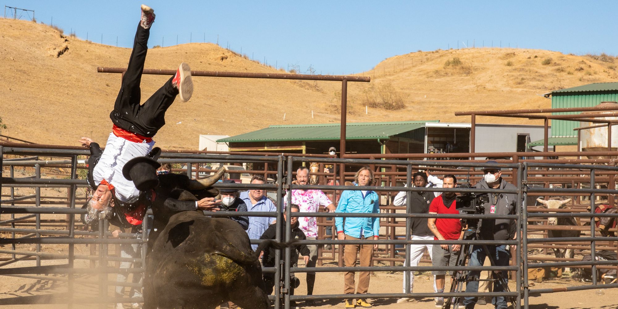 jackass forever johnny knoxville getting throw into the air by a bull as the cast watches on