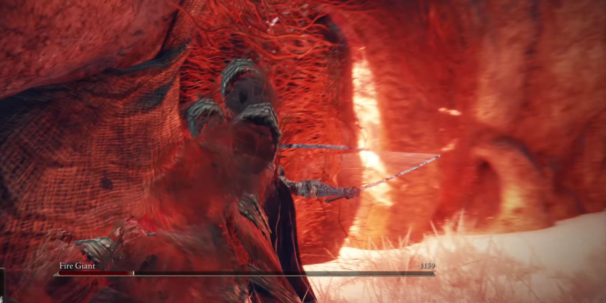 The Fire Giant breathing fire out of its body face after performing an elbow drop in Elden Ring