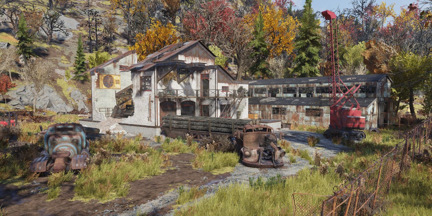 The Gilman Lumber Mill sits amongst rusted fences and a colorful treeline in Fallout 76.