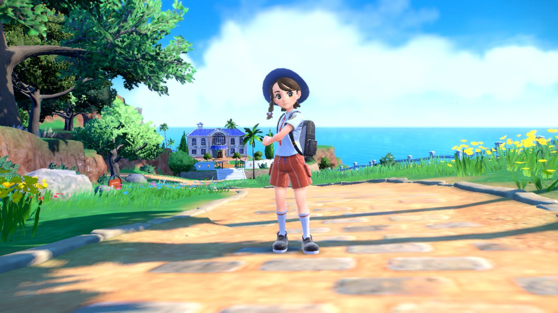 Screenshot of Pokemon Scarlet & Violet showing the female main character standing on a path toward a large building