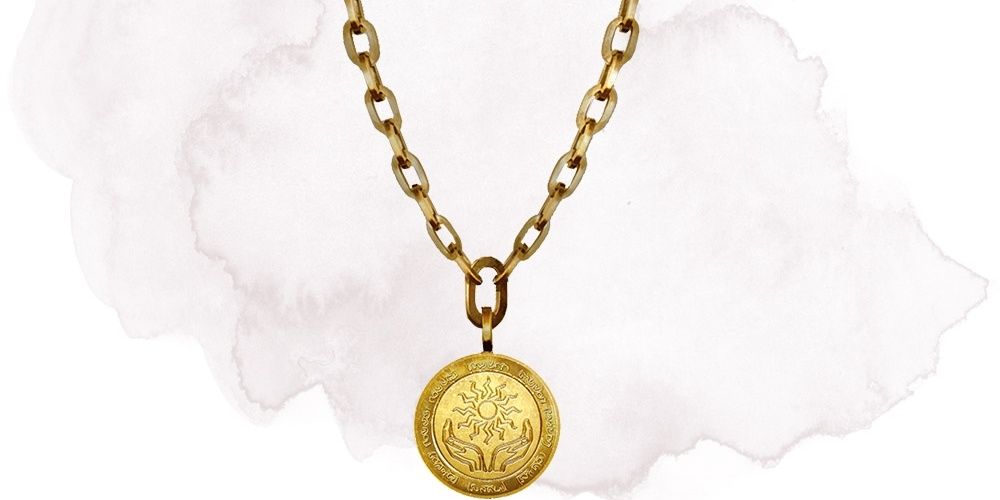 golden amulet hanging from chain with sun on it