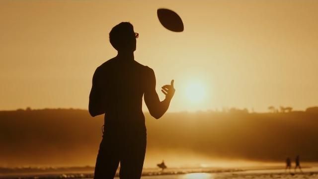 Glen Powell in Top Gun throwing a football