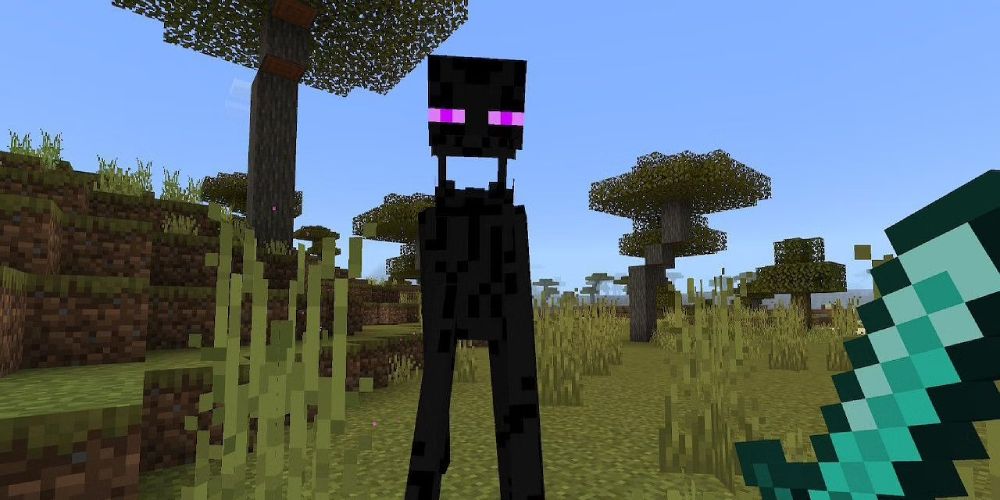 a POV shot of an angry Enderman from Minecraft with its head extended in a field with trees behind it and a sword being held by the player in the foreground