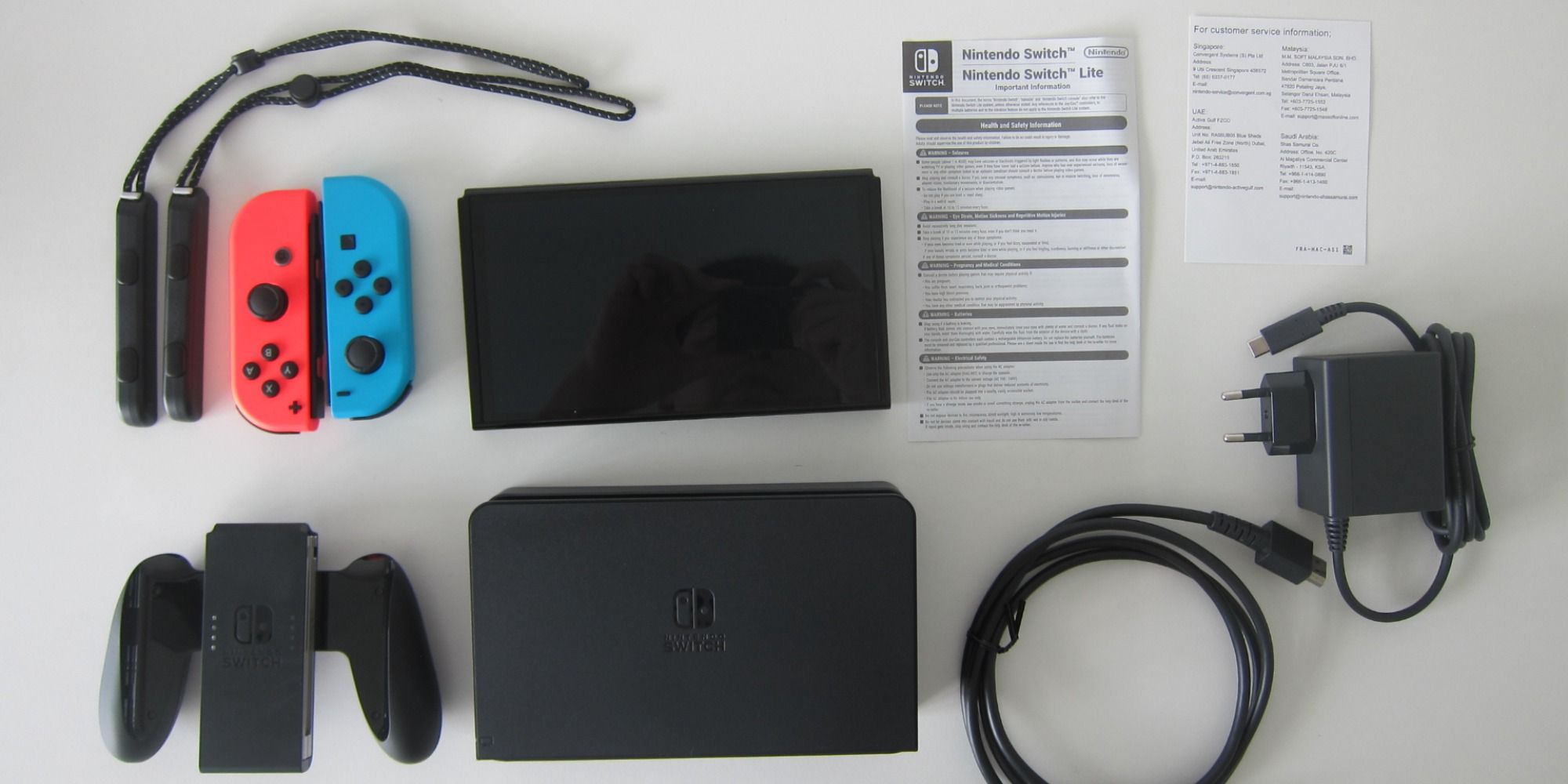 A photo showing the contents of the Nintendo Switch OLED box including instruction booklets