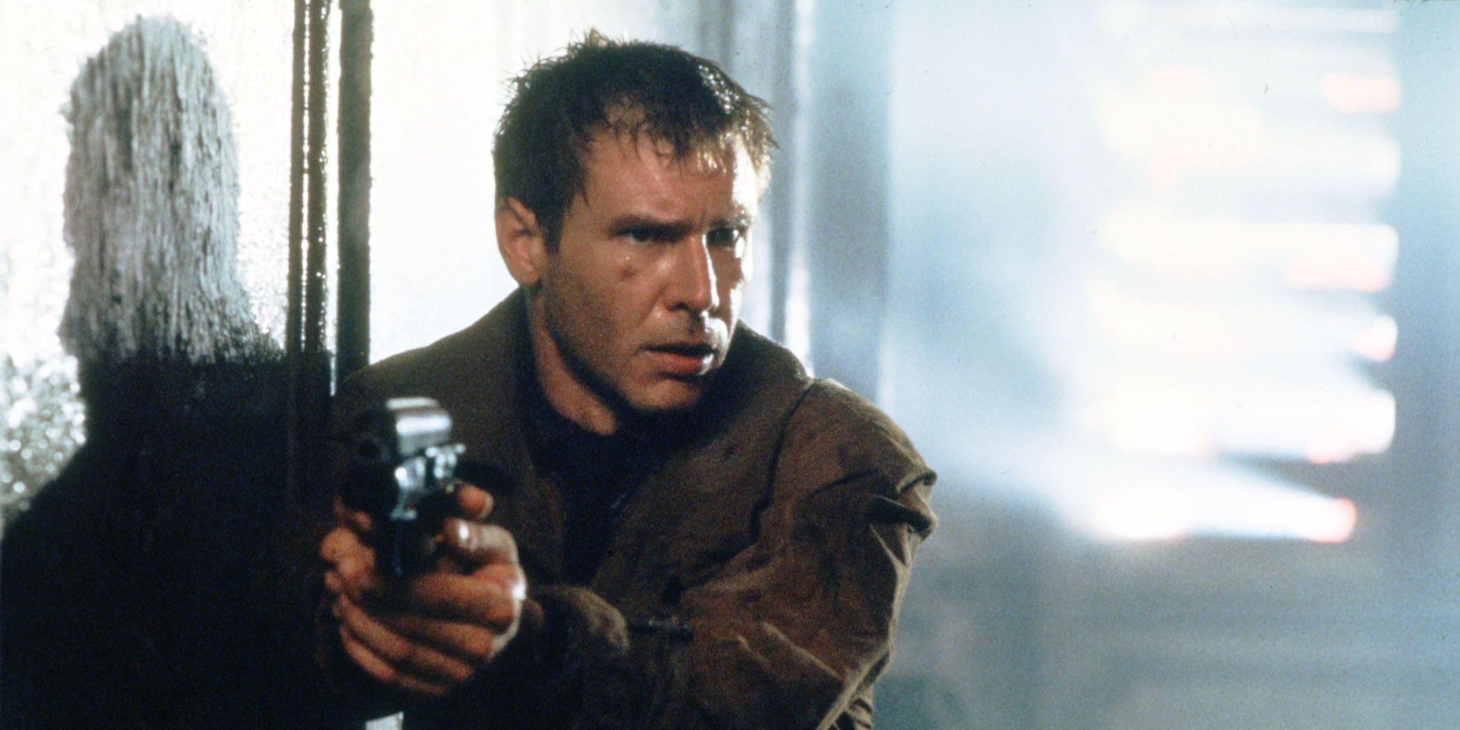 A photo still showing Rick Deckard pointing a gun in Blade Runner