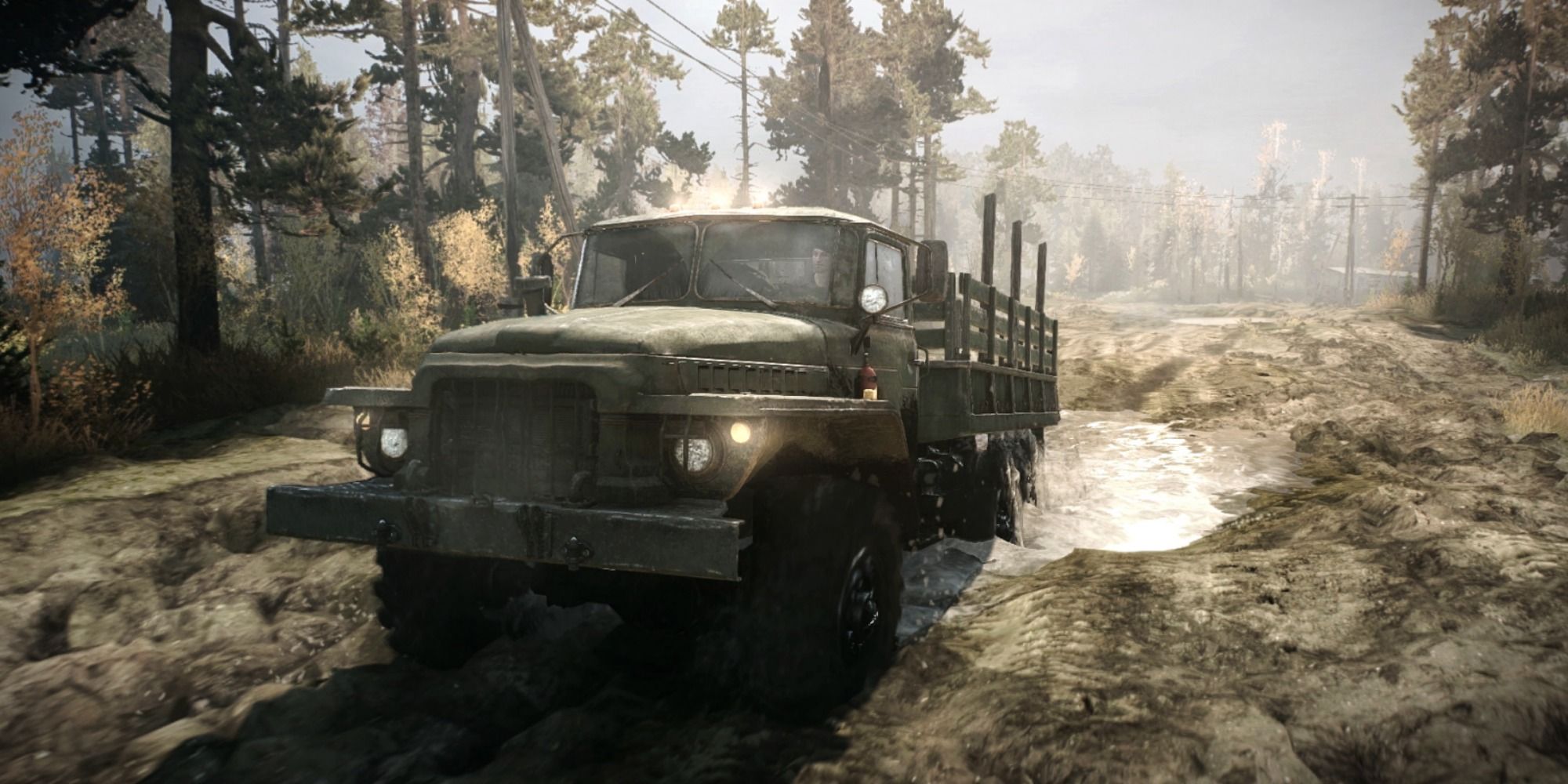 mudrunner truck driving through mud and water in forest