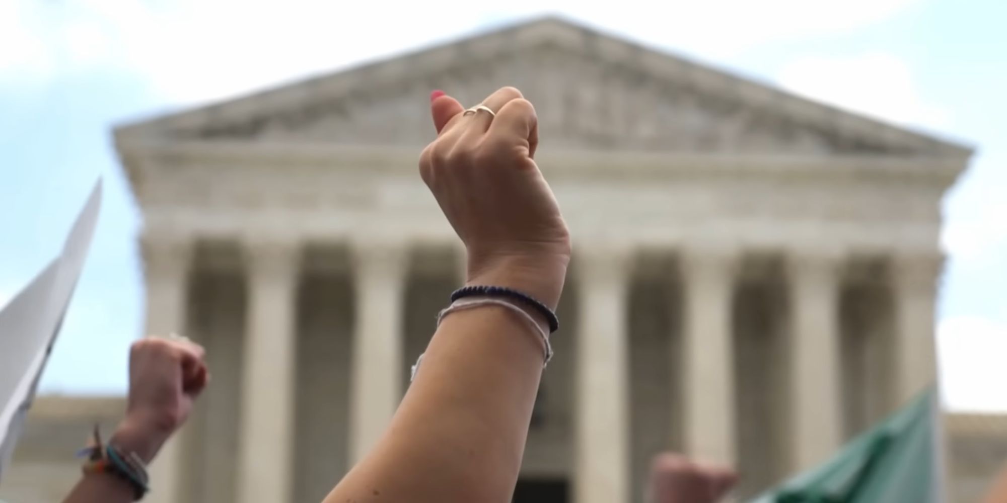 Arms raised in protest against the Supreme Court decision to overturn Roe v. Wade