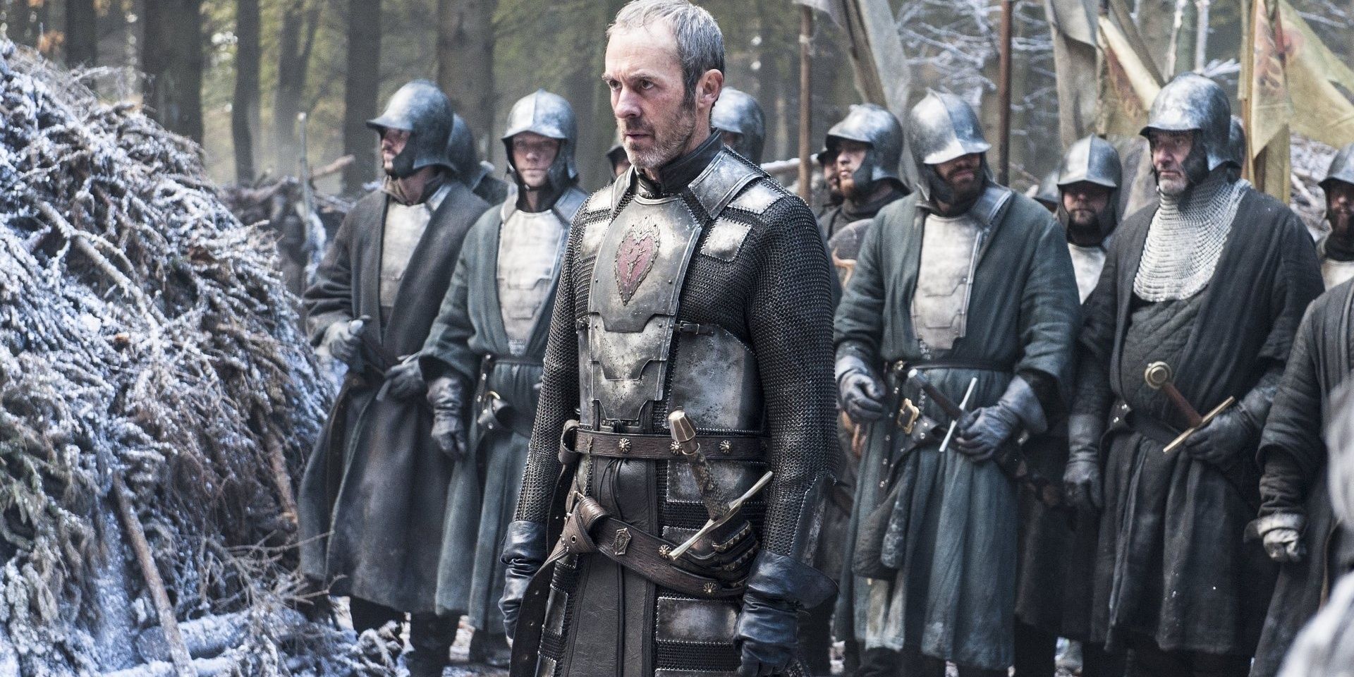 stannis stands in a forest with his soldiers