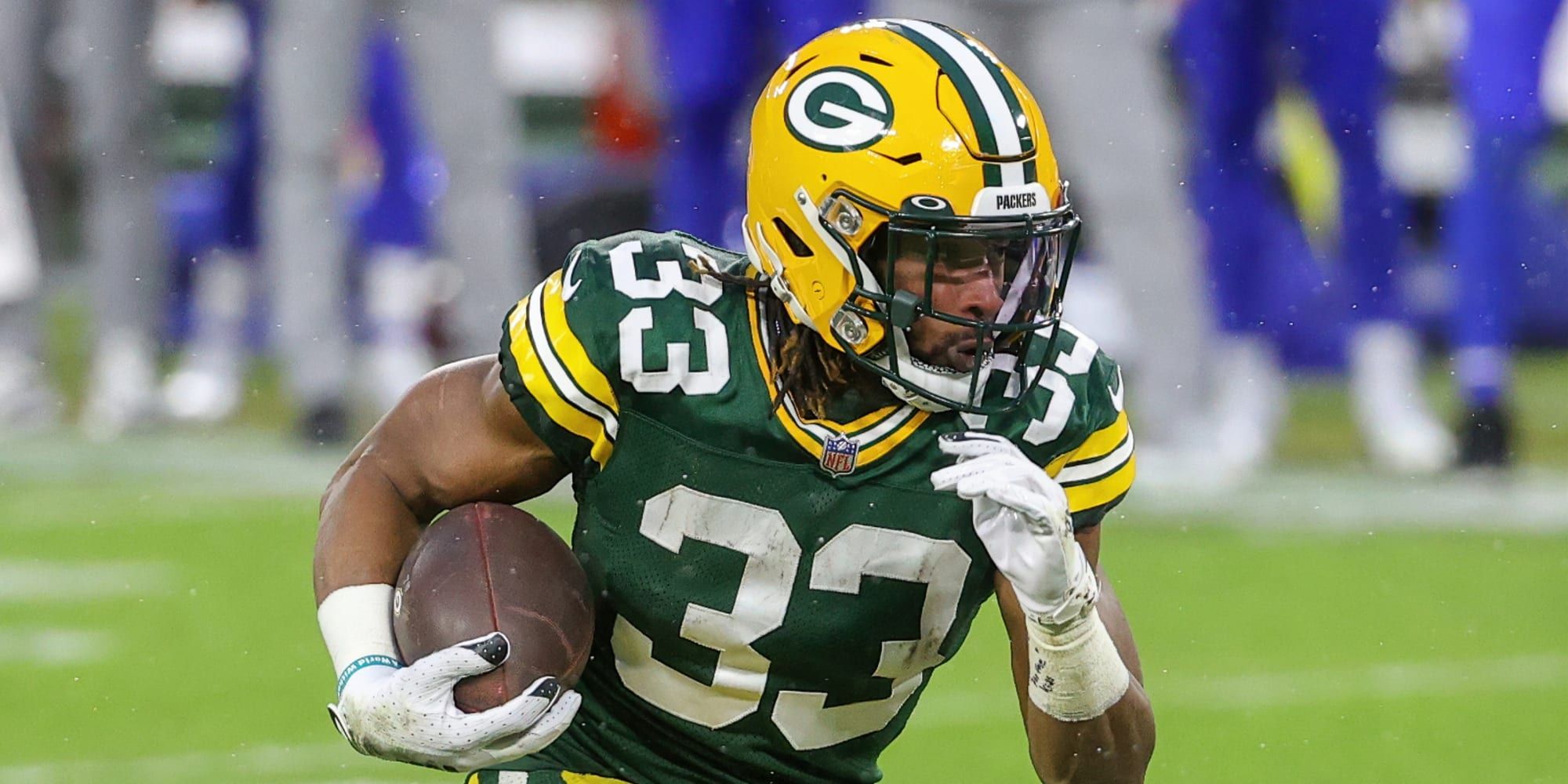 Aaron Jones running the ball in green Packers jersey