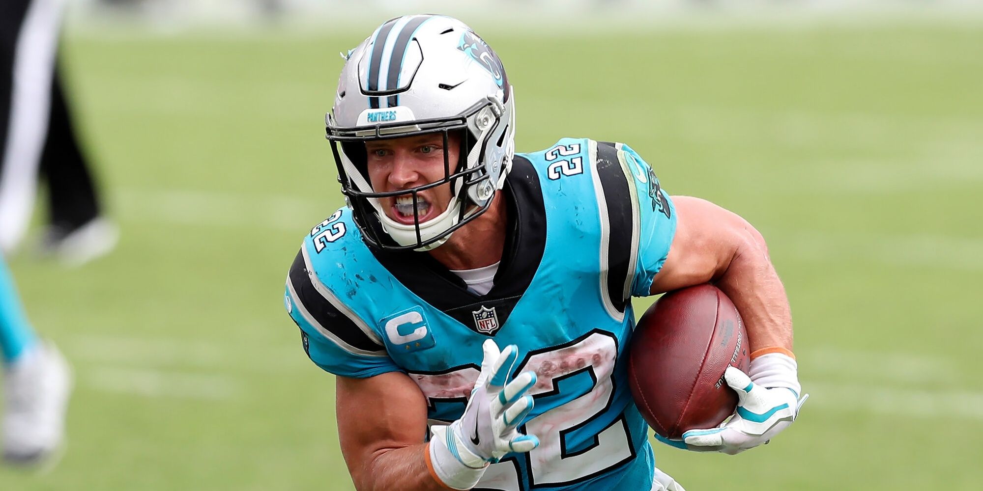 Christian McCaffrey angrily running the ball in light blue Panthers jersey