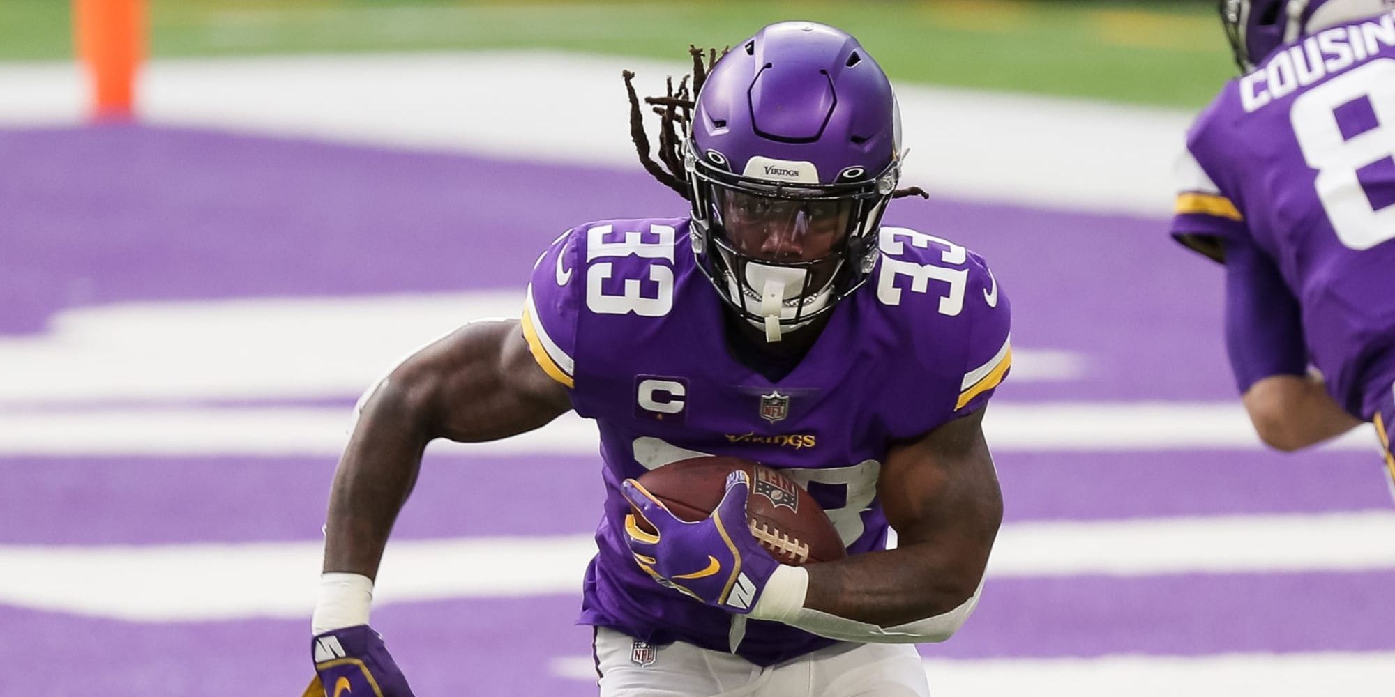 Dalvin Cook running the ball near his own end zone in a purple Vikings jersey