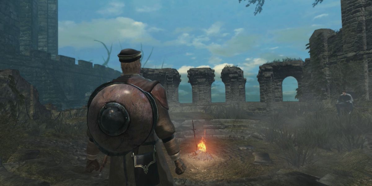 The chosen undead standing near a lit bonfire in  Firelink Shrine in Dark Souls