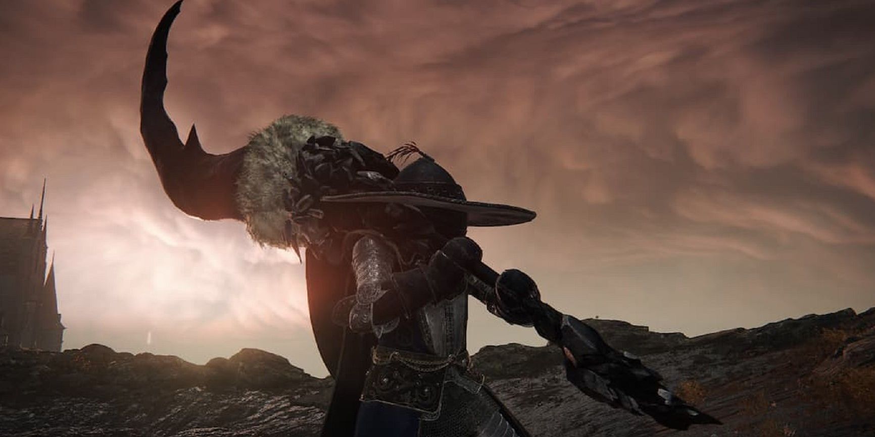 Elden Ring character holding the Fallingstar Beast Jaw weapon with a sunset behind him