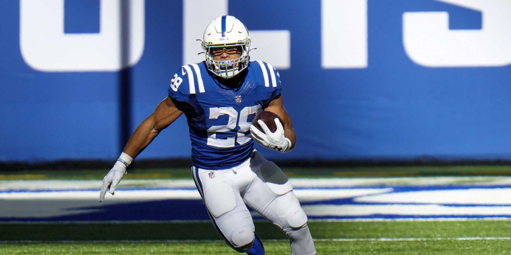 Jonathan Taylor running the ball in blue Colts jersey