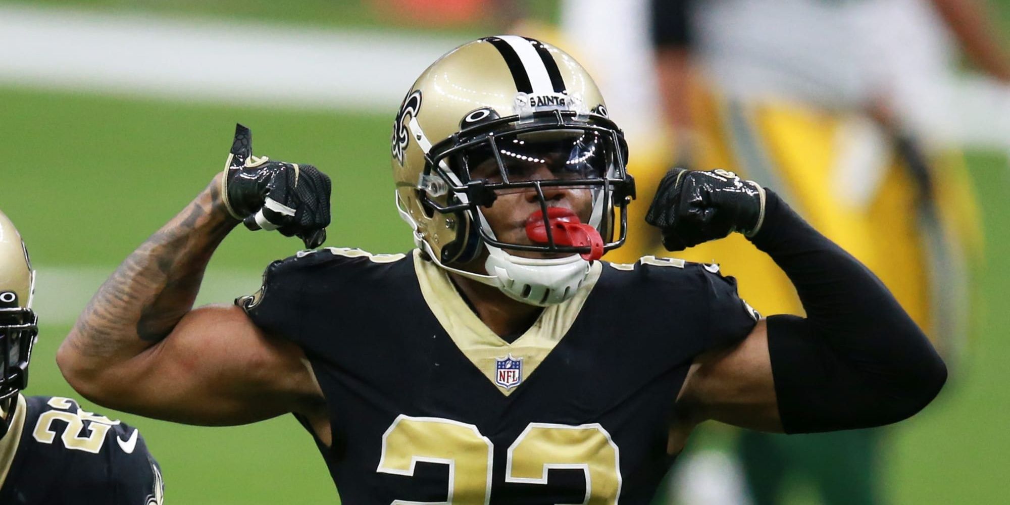 Marshon Lattimore flexing in a black Saints jersey