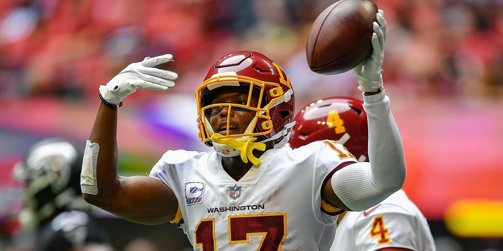 Terry McLaurin celebrating a catch in a white Commanders uniform