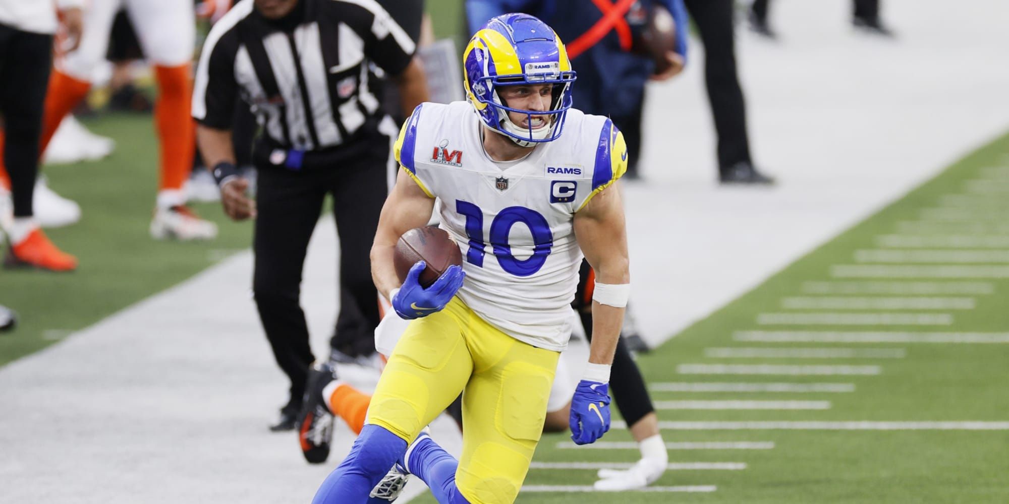 Cooper Kupp running with the ball down the right sideline in a white, blue, and yellow Rams jersey