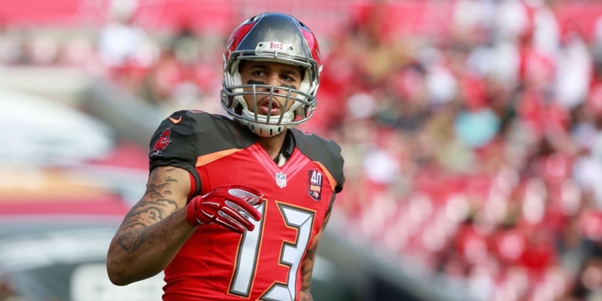 Mike Evans looking off into the distance in a red Buccaneers uniform