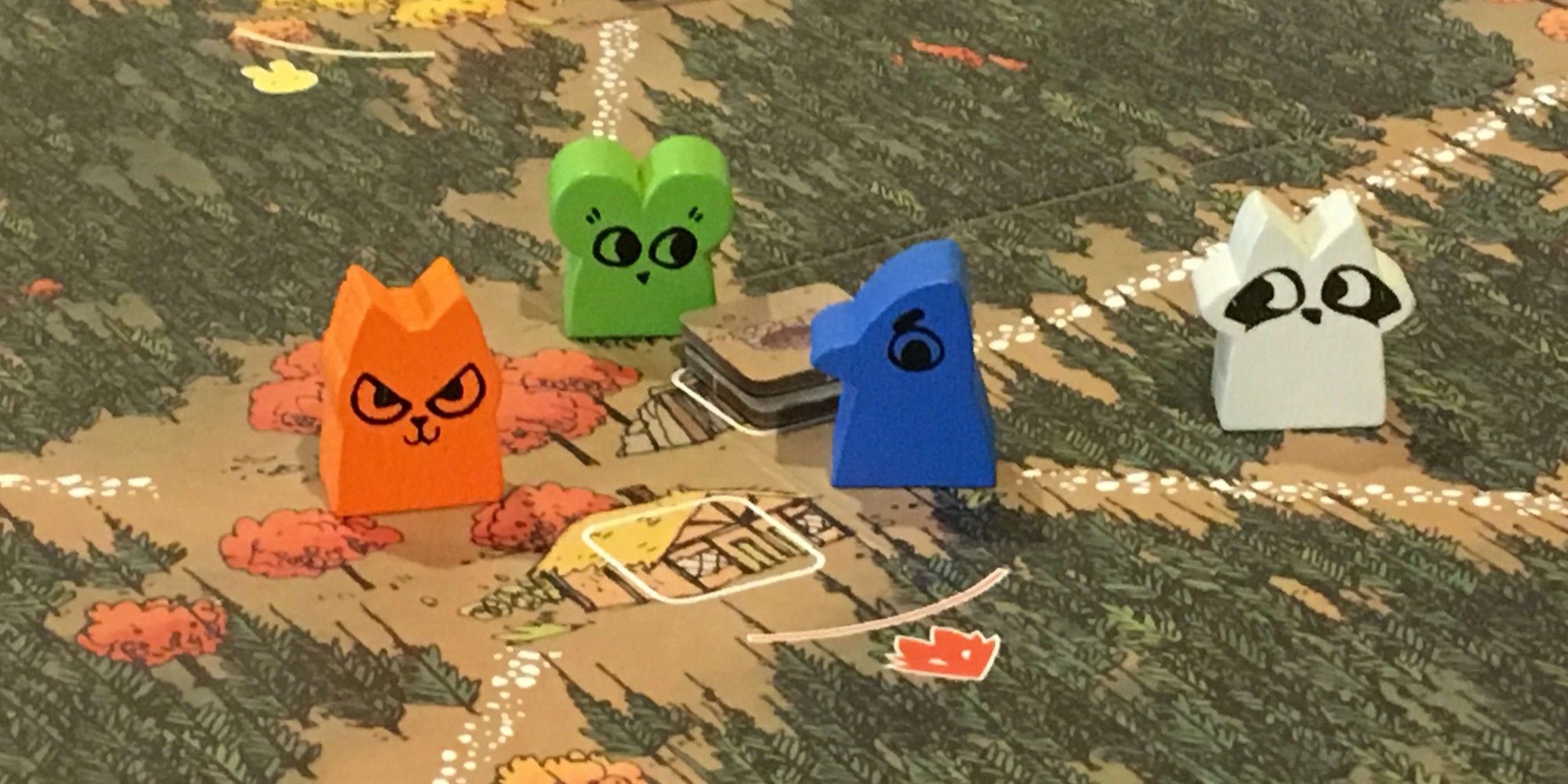 Route board game, four different meeples on a jungle map