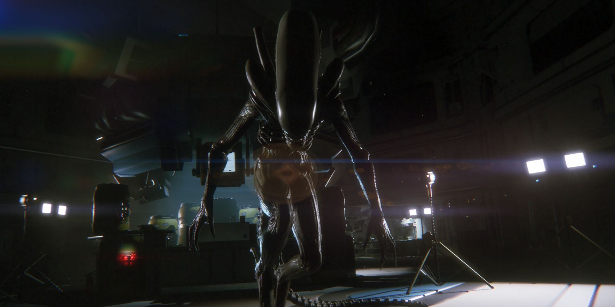 The Xenomorph faces the player in the space station as surrounding lights shine from behind it