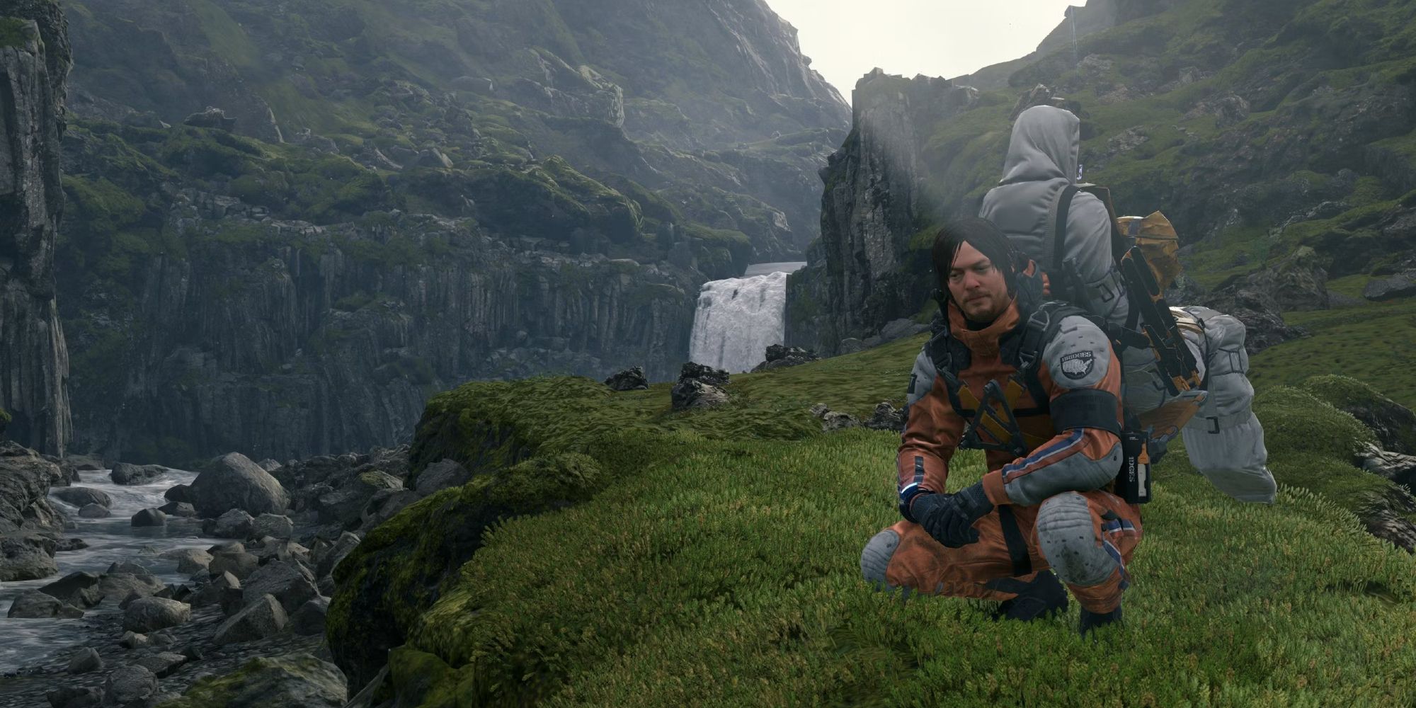 Sam from Death Stranding kneeling next to a river