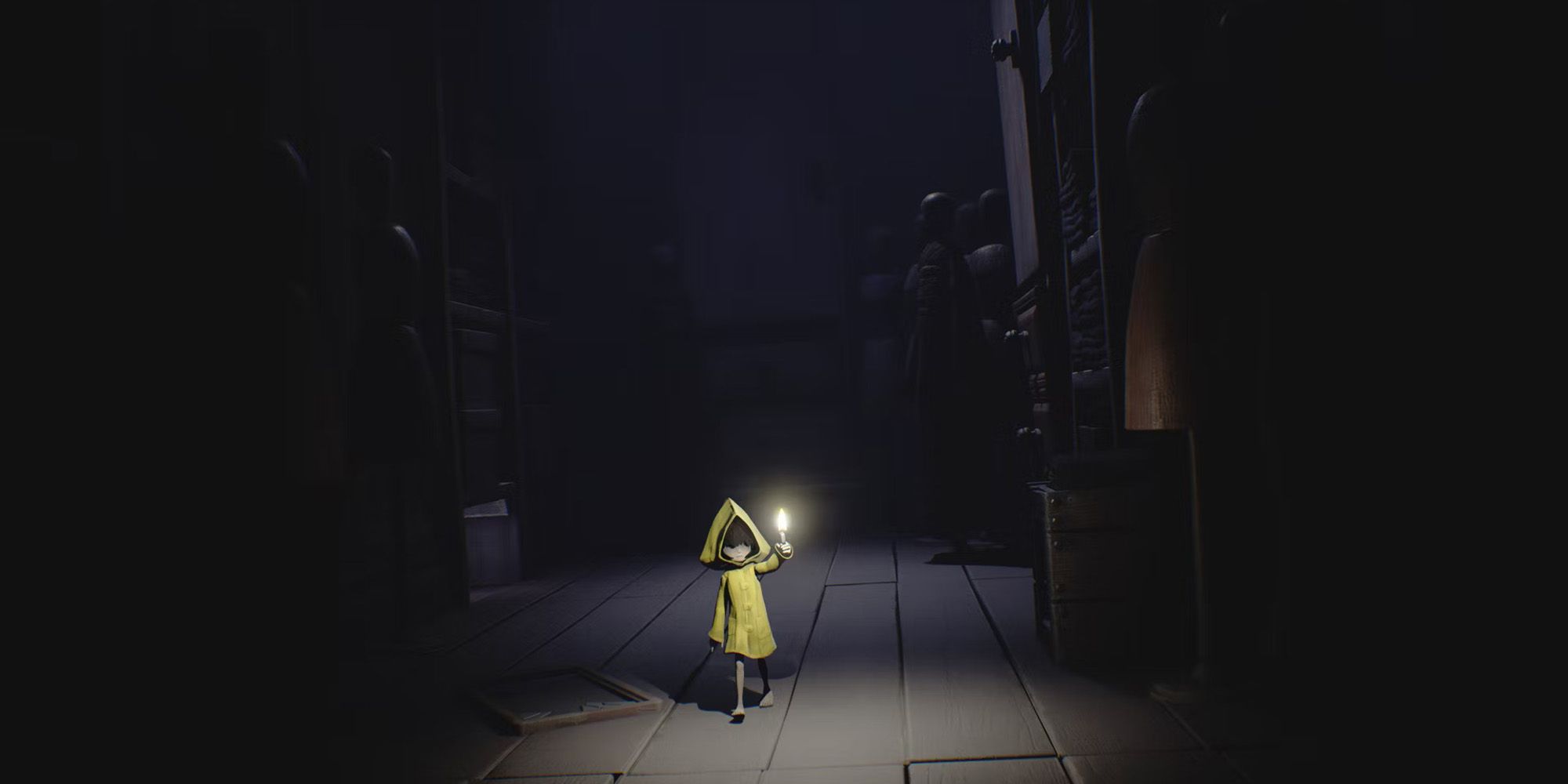little nightmares six holding a candle in a dark room