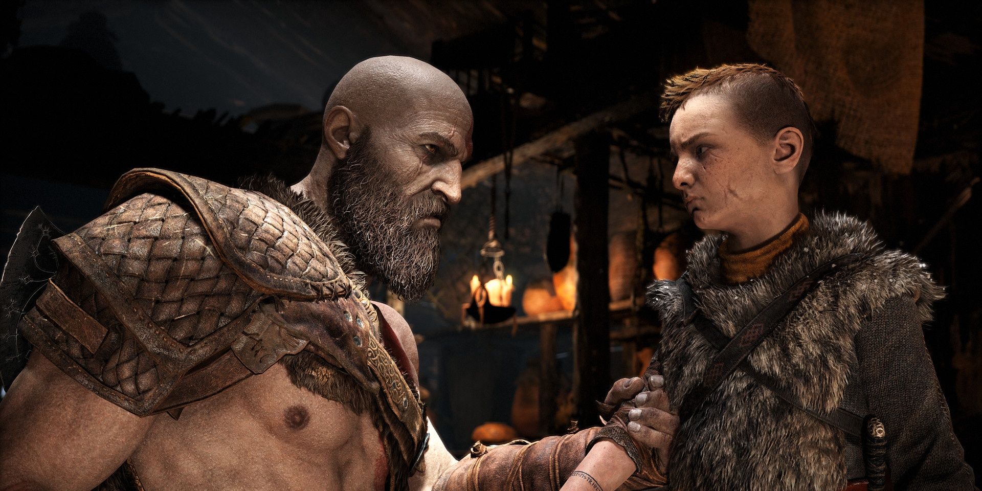 Kratos holding the arm of Atreus in God of War
