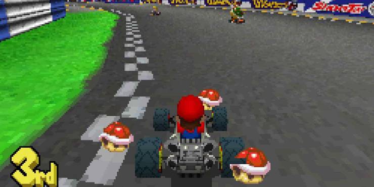 Mario drives by grass with three red shells surrounding him