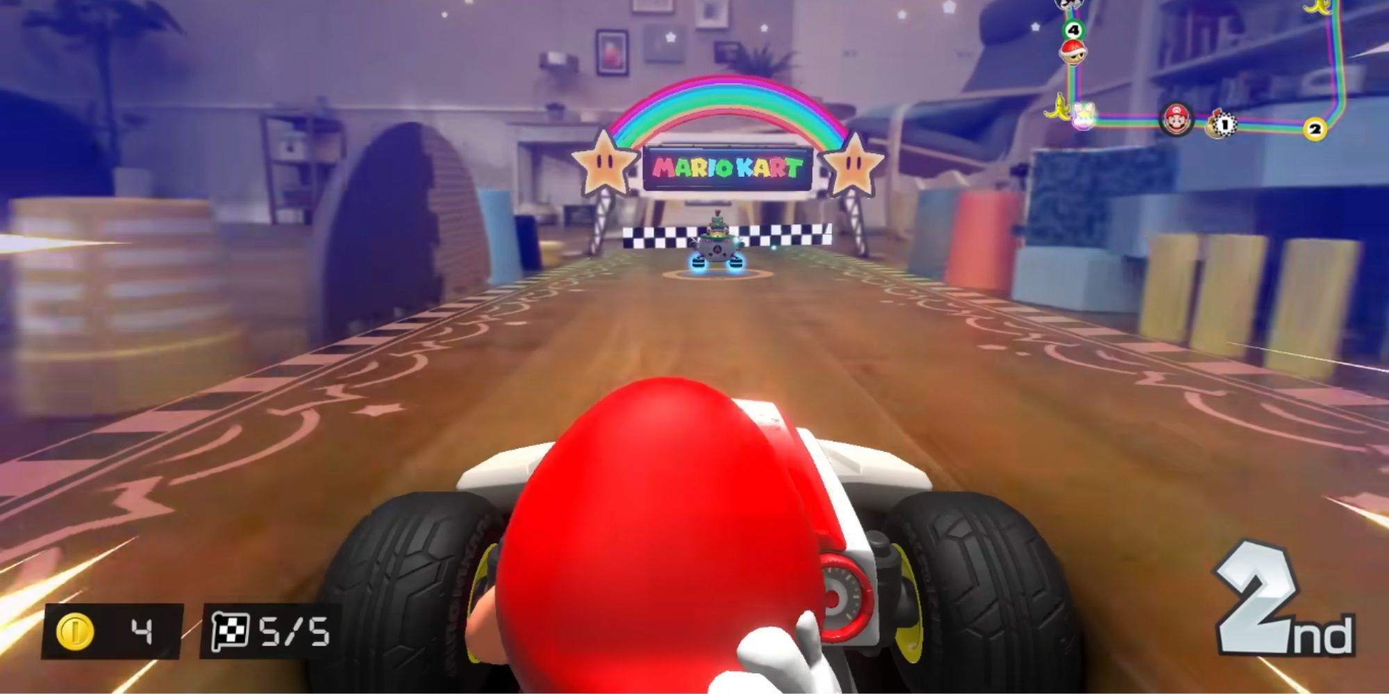 Mario drives behind Bowser Jr. on a living room floor