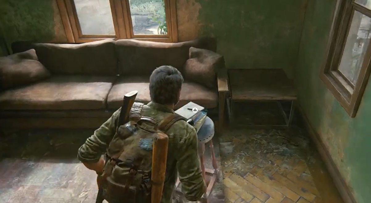 Joel runs toward a dart on a bench in a living room in The Last of Us Part 1