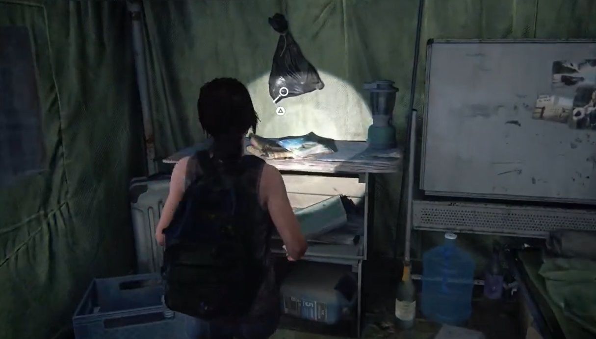 Ellie stands in front of a table inside a tent in The Last of Us Part 1 Left Behind