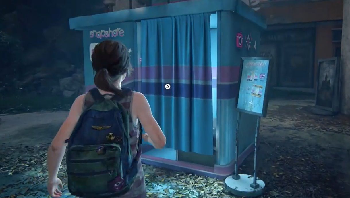 Ellie stands front of a phonebooth called ShareSnap in The Last of Us Part 1 Left Behind