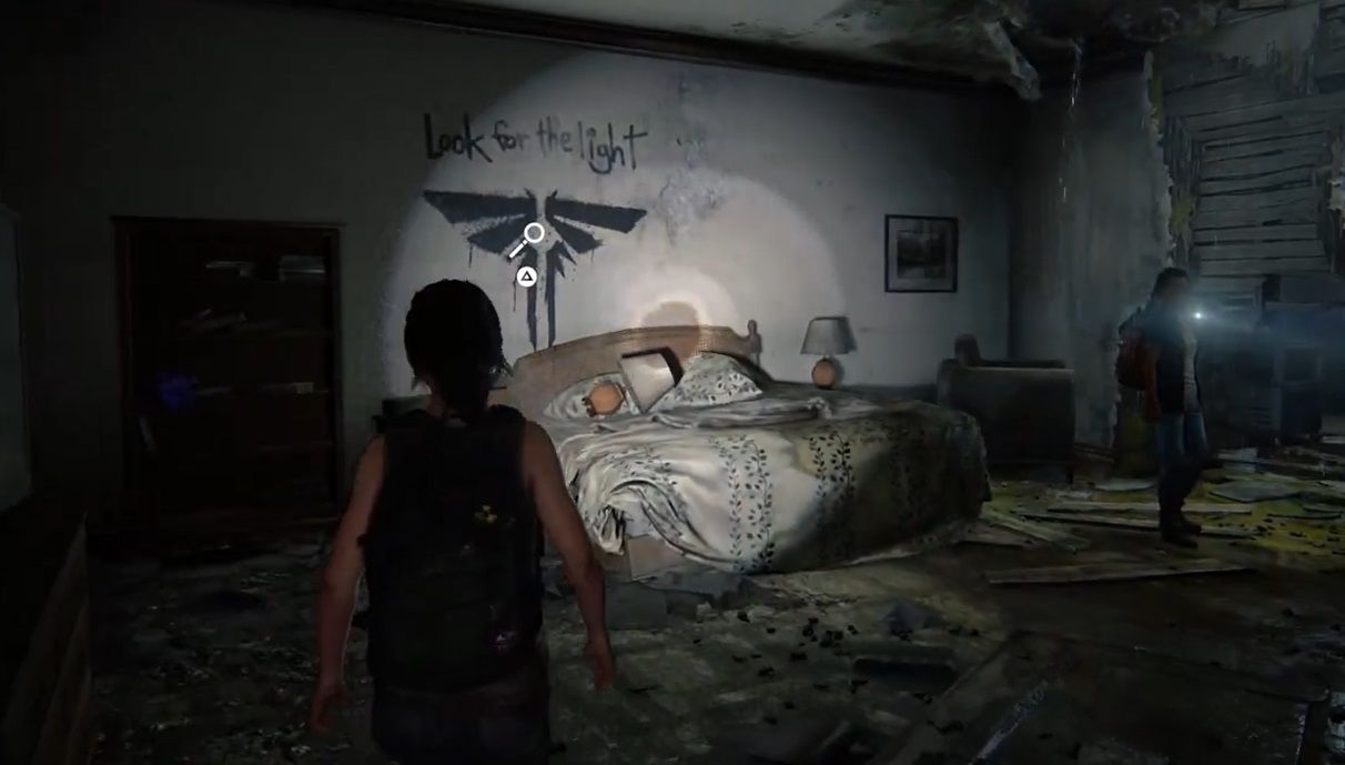 Ellie looks at the firefly on a wall near a bedroom with Riley in The Last of Us Part 1 Left Behind 