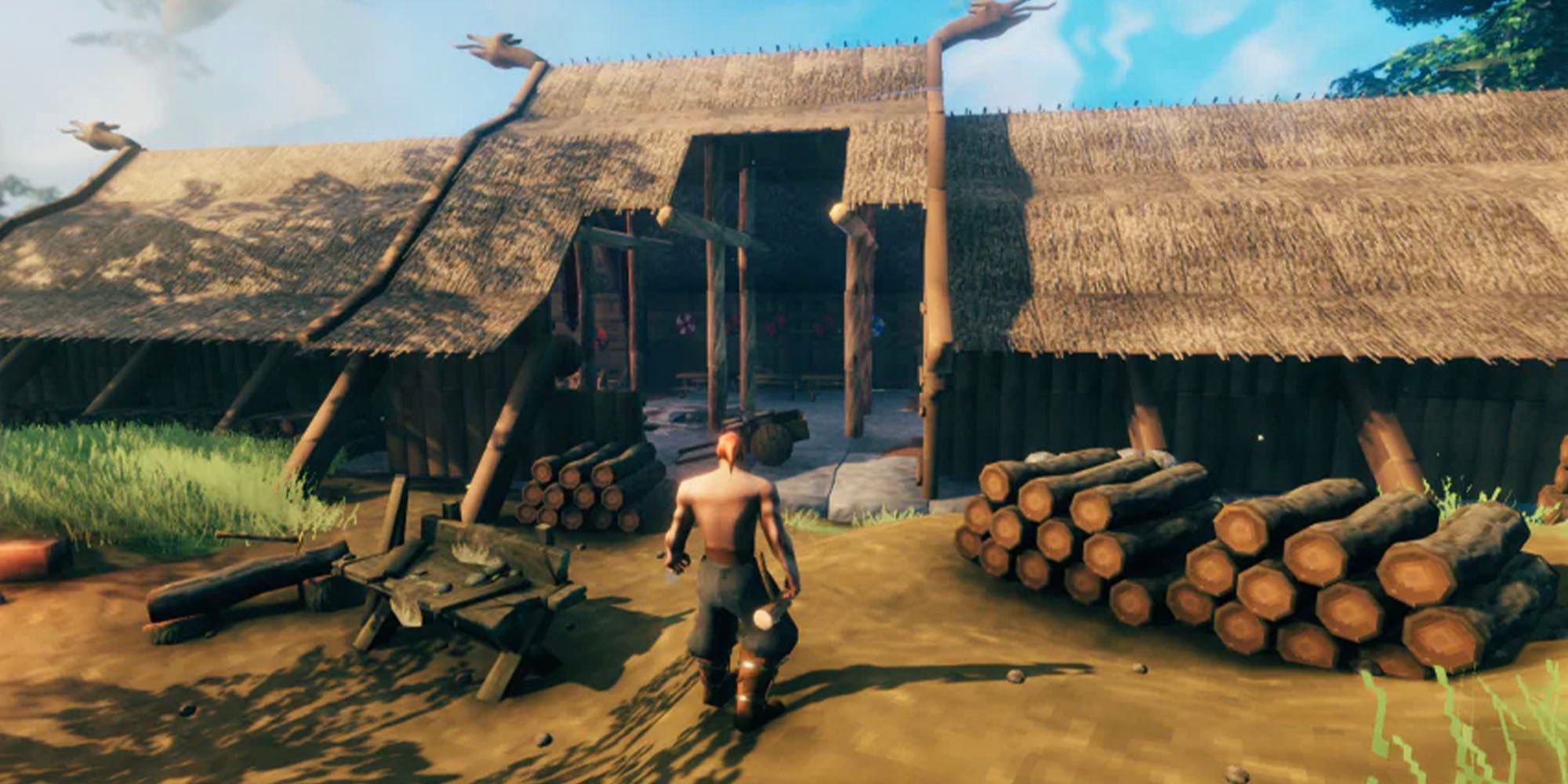 The hero of Valheim has built a long house and is walking towards the door area