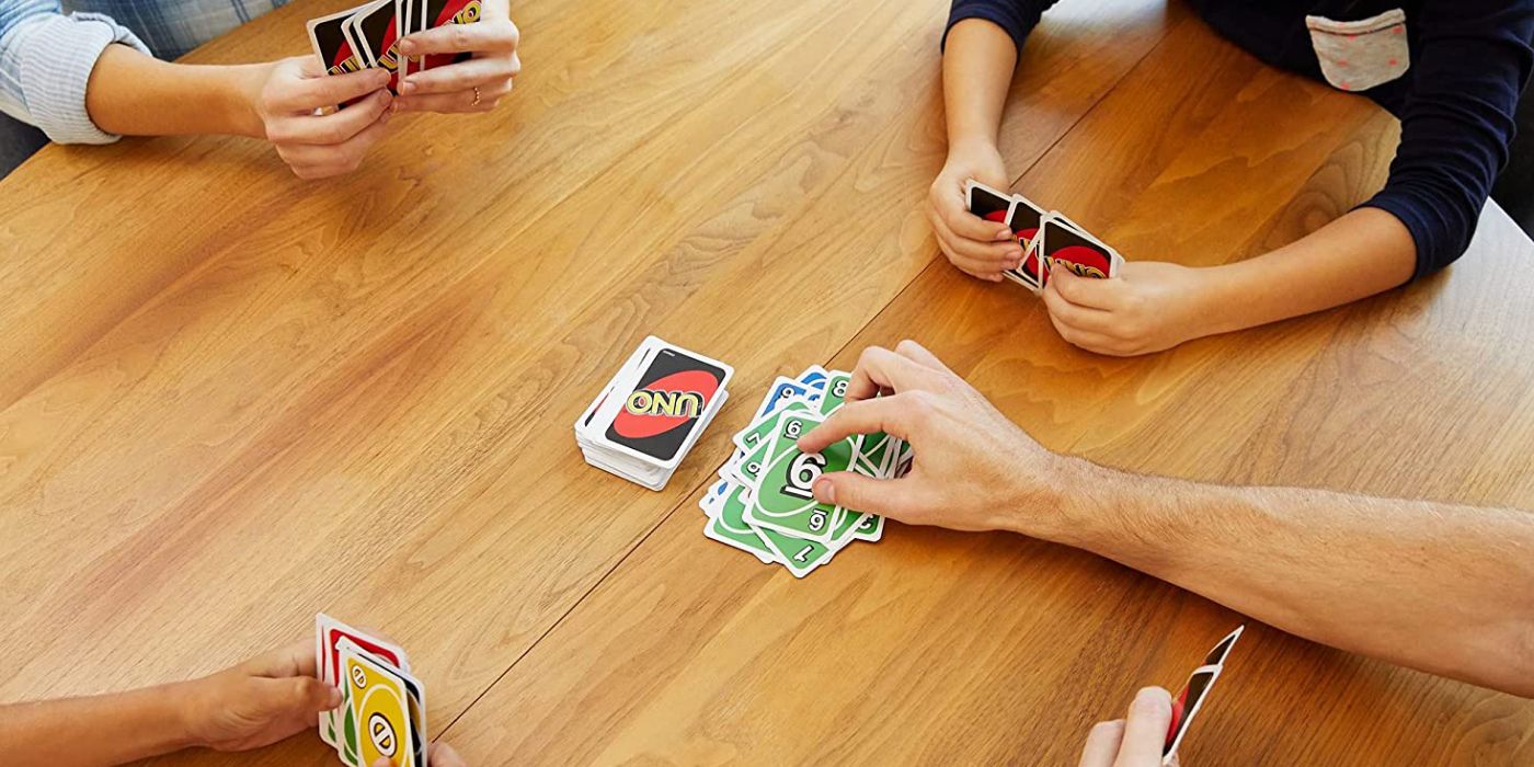 Four people playing uno