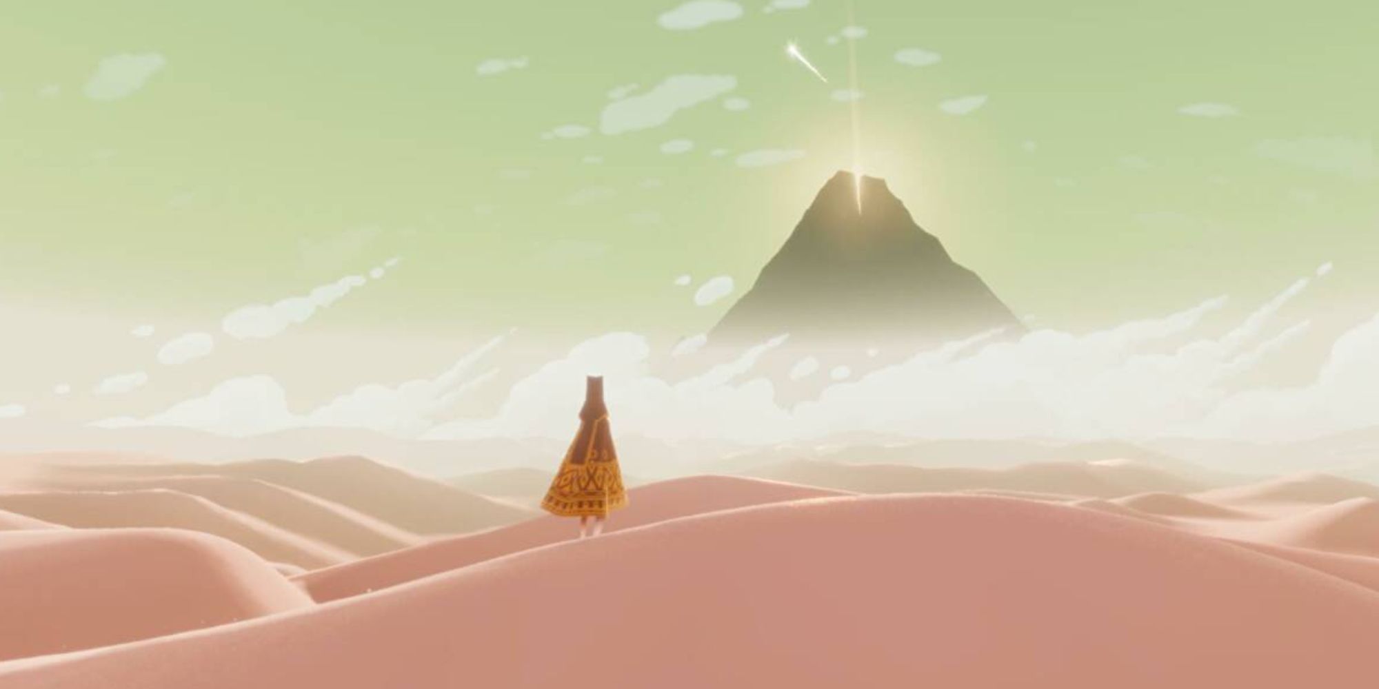 The traveler looks at the mountain in the distance in the desert in Journey