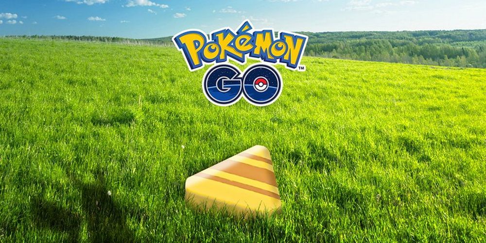 A piece of Candy XL from Pokemon Go in grass with the Pokemon Go logo above it