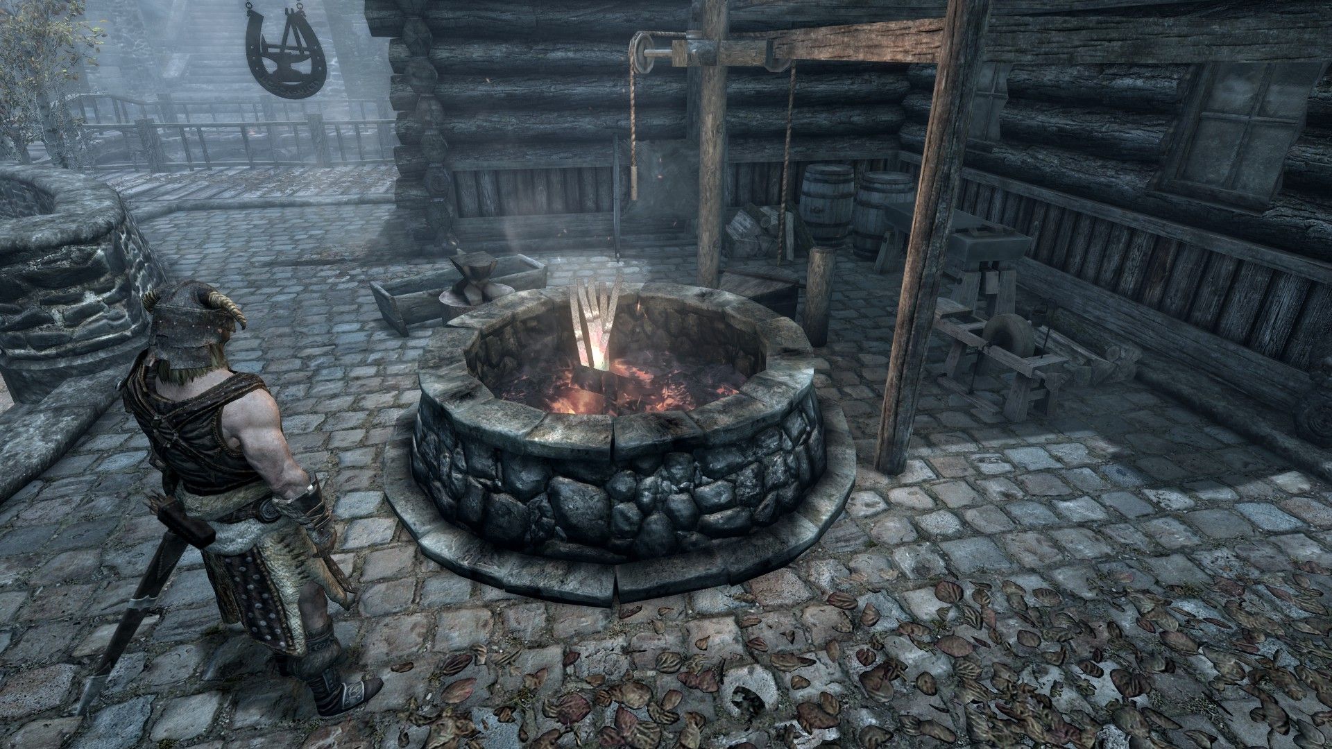 An adventurer looks at a smoldering forge within a medieval city. 