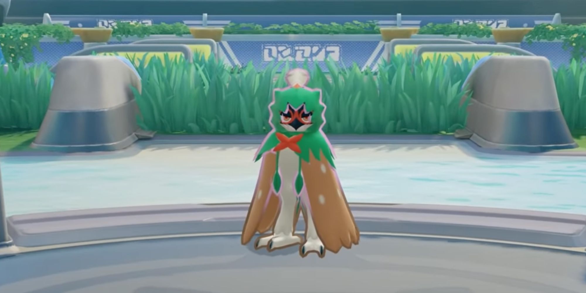 Decidueye standing with its wings at its sides in front of some tall grass.