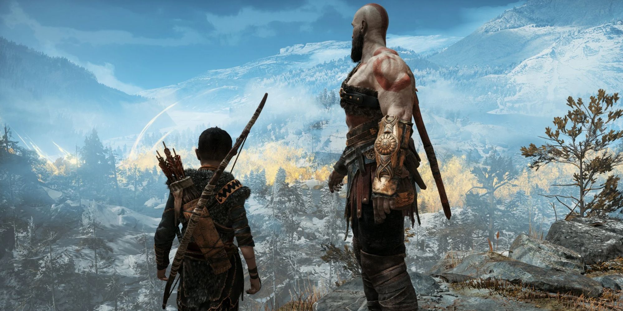 Kratos and Atreus overlooking a snowy mountain landscape and forest in God of War
